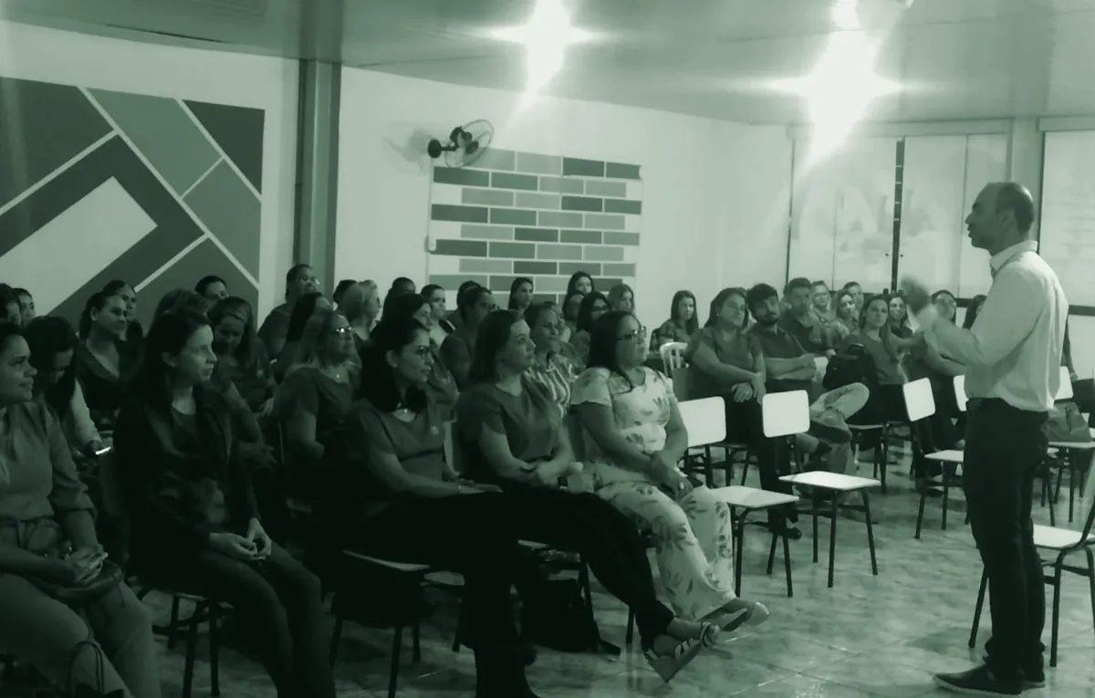 Alisson Faria falando para uma sala cheia